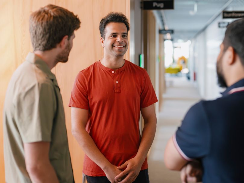 Three Superhuman team members talk in a corridor